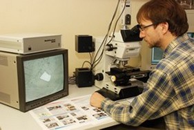 Dr. Frank Melcher studying a tantalum ore sample under the microscope